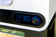 Digital timer display on a kitchen appliance with a blurred outdoor background