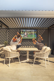 Friends watching football on an outdoor TV under a louvred pergola